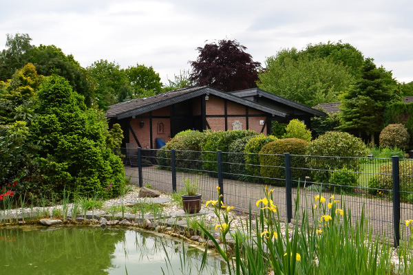 Umzäunter Gartenteich vor dem Haus