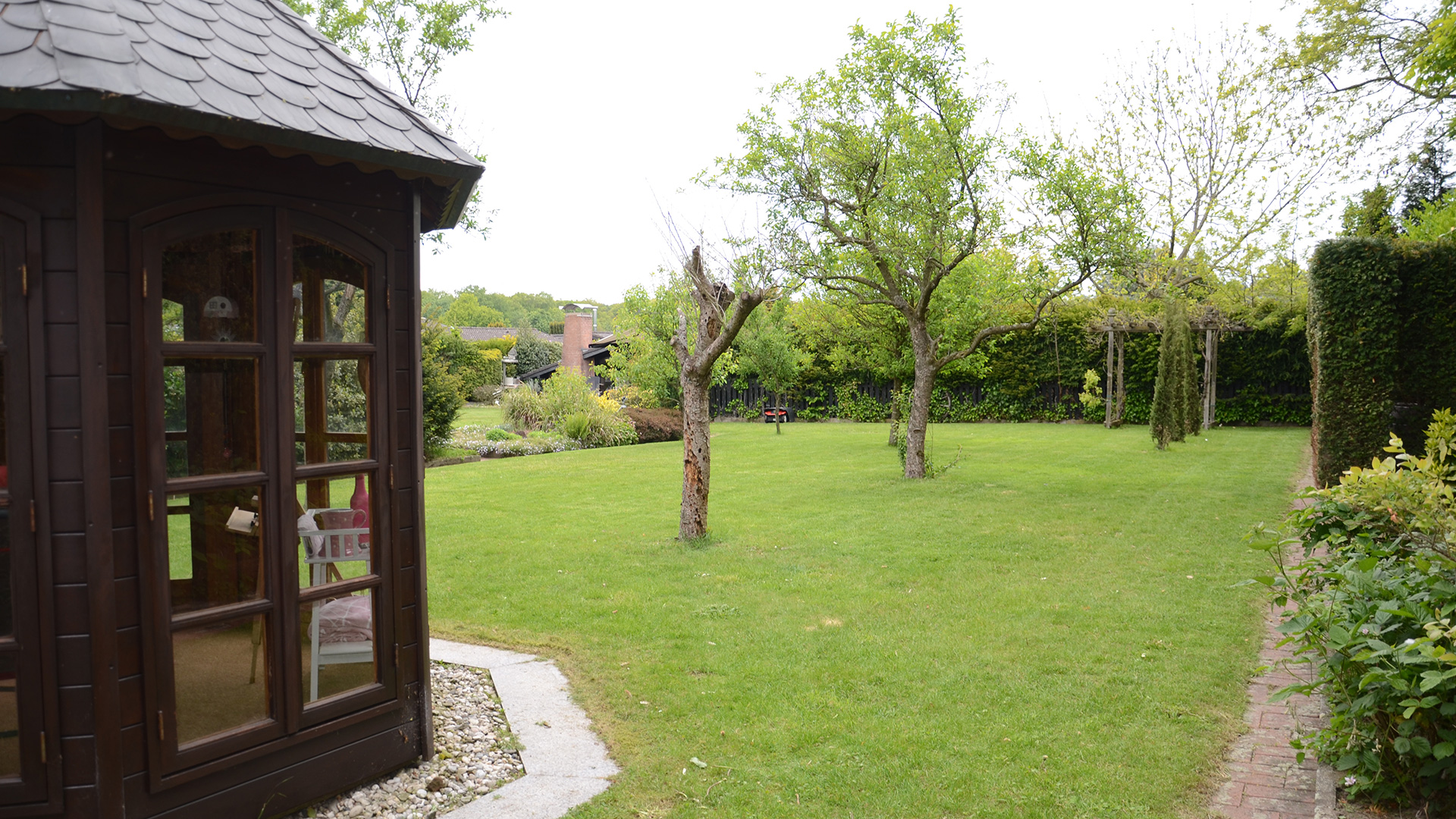 Rasenfläche mit Teehaus im Garten des Ferienhauses