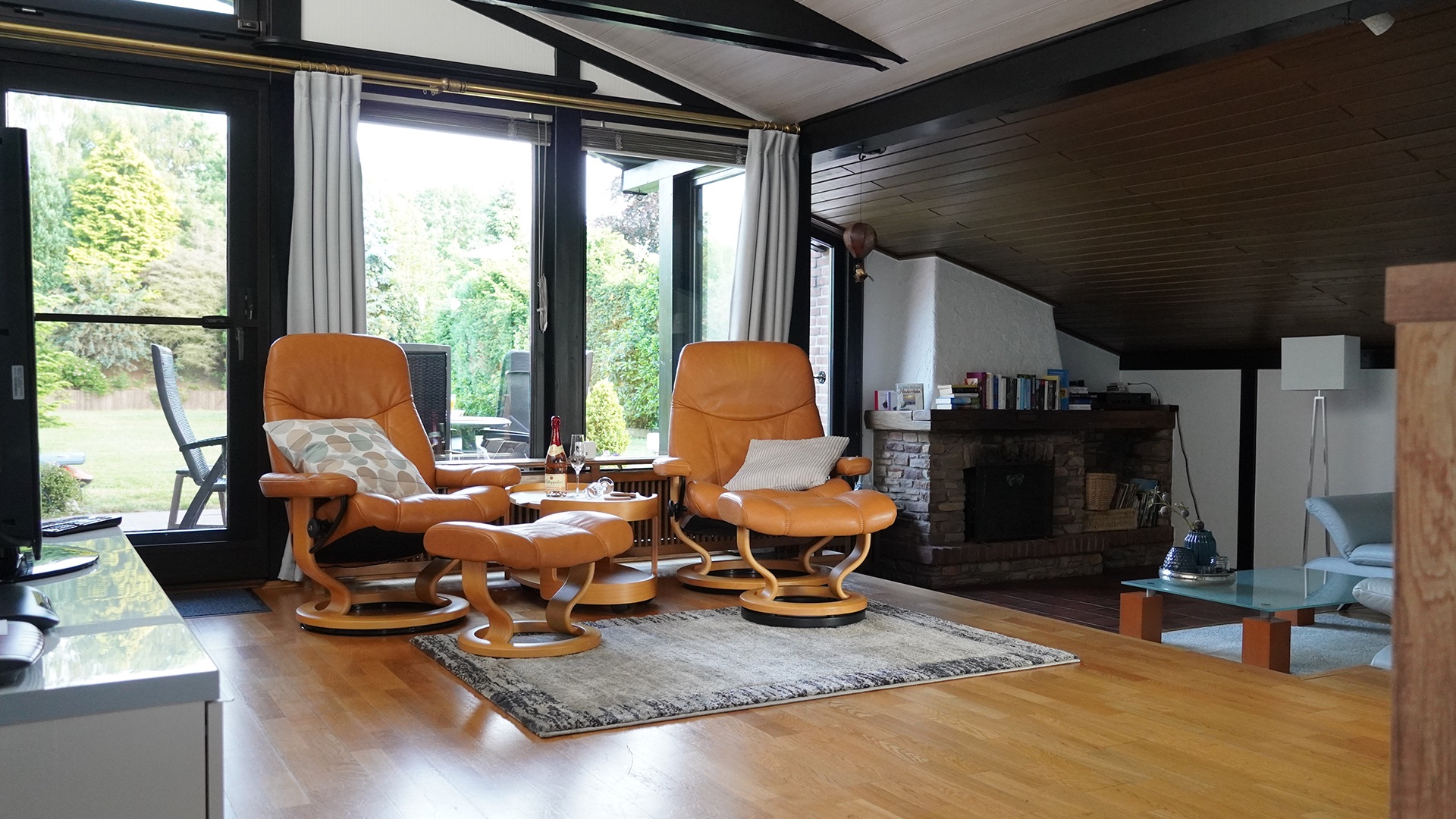 Heller Wohnbereich mit Ledercouch und Blick in den Garten